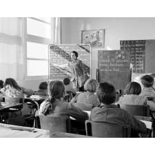 Ecole primaire. L'institutrice fait lire aux élèves un texte écrit sur le tableau noir.