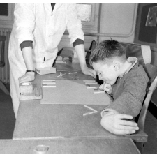 Centre de réadaptation fonctionnelle : un élève procède à des exercices de logique, sous contrôle d'une éducatrice.