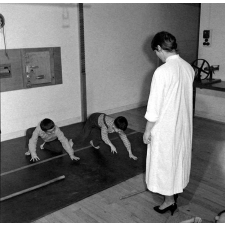 Centre de réadaptation fonctionnelle : un élève procède à des exercices d'assouplissement, sous contrôle d'une éducatrice.