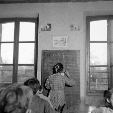 Méthode Freinet : l'apprentissage de l'imprimerie et la réalisation d'un journal scolaire. Une élève rédige un texte au tableau noir.