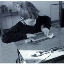 Ecole primaire. Un élève efface son ardoise.