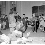 Enseignement musical. Une fillette dirige un orchestre d'écoliers de maternelle.