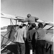 Ecole Freinet, classe promenade : les élèves observent le pilote et le cockpit d'un biplan.