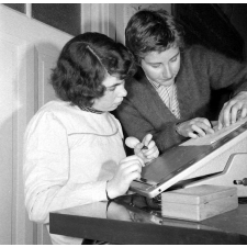 Collège d'enseignement technique pour jeunes filles. Le professeur de sténodactylographie conseille une élève pour graver un stencil.
