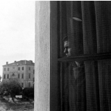 Centre d'éducation surveillée : solitude. Un jeune à la fenêtre, le regard perdu vers le monde extérieur...
