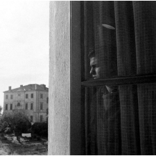 Centre d'éducation surveillée : solitude. Un jeune à la fenêtre, le regard perdu vers le monde extérieur...