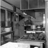 Collège d'enseignement technique pour jeunes filles. La cuisine. La cuisinière prépare les plats.