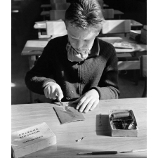Méthode Freinet : l'apprentissage de l'imprimerie et la réalisation d'un journal scolaire. L'écriture d'un article. Un élève réalise un dessin sur une planche (linogravure).