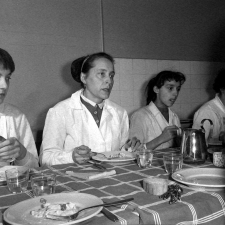 Collège d'enseignement technique pour jeunes filles. Le cours de cuisine. Le professeur et les élèves goûtent les plats préparés.