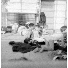 Ecole de plein air : lecture sur le sol : au milieu des vêtements : avant la visite médicale