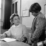 Ecole primaire, classe de Madame Hardy : l'institutrice vérifie le cahier de poésie d'une élève.