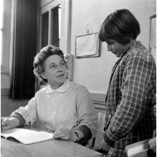 Ecole primaire, classe de Madame Hardy : l'institutrice vérifie le cahier de poésie d'une élève.