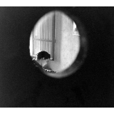 Centre d'éducation surveillée : l'oeil du rééducateur, observant un jeune dans sa cellule (chambre).