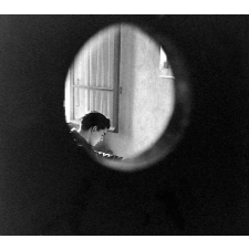 Centre d'éducation surveillée : l'oeil du rééducateur, observant un jeune dans sa cellule (chambre).