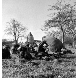 Ecole Freinet, classe promenade : les élèves, couchés sur l'herbe, observent et rédigent, guidés par leur maître.