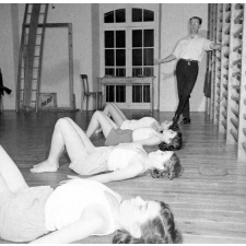 Service de la jeunesse et des sports : la rééducation neuro-motrice. Des jeunes filles pratiquent des exercices d'assouplissement (extension dorsale haute).