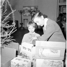 Arbre de Noël : remise d'un jouet à une enfant