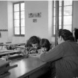 Ecole primaire : Institutrice vérifiant le travail de deux élèves
