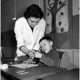 Centre de réadaptation fonctionnelle : un élève apprend à peindre, sous contrôle de son éducatrice. La préhension de l'outil.