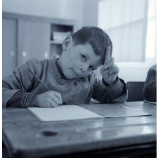 Ecole primaire. Un élève écrit lettres et syllabes.