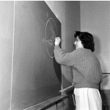 Collège d'enseignement technique pour jeunes filles. Une élève réalise une figure géométrique au tableau.