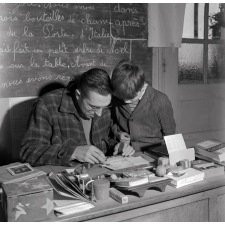 Méthode Freinet : l'apprentissage de l'imprimerie et la réalisation d'un journal scolaire. L'écriture d'un article. L'élève et le maître vérifient les caractères d'imprimerie.