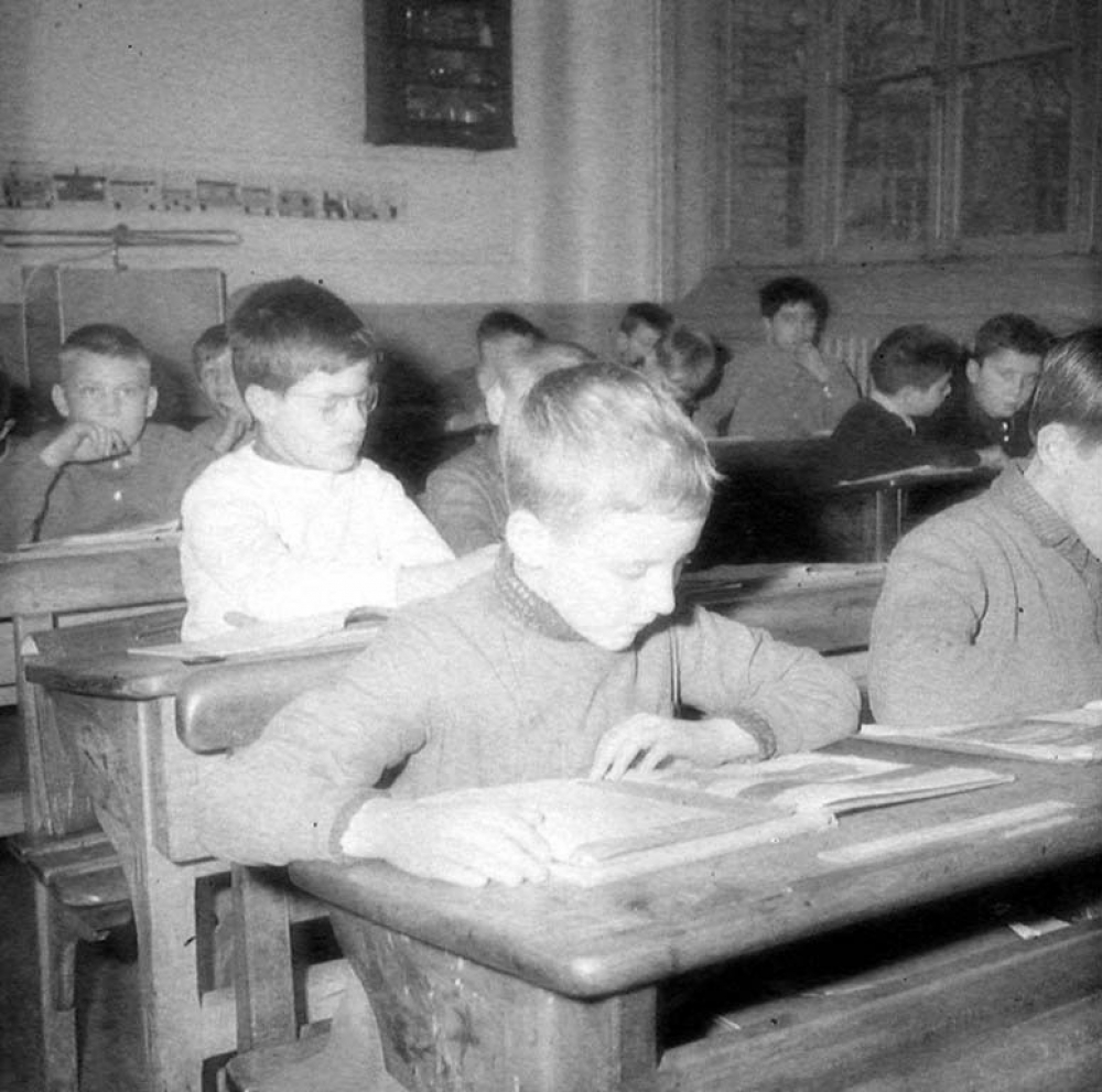 Ecole primaire de plein air : un garçon lit un livre illustré