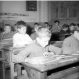 Ecole primaire de plein air : un garçon lit un livre illustré