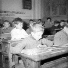 Ecole primaire de plein air : un garçon lit un livre illustré