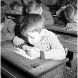 Ecole de garçons, rue Montcenis : exercice d'écriture dans la classe : un jeune garçon s'applique