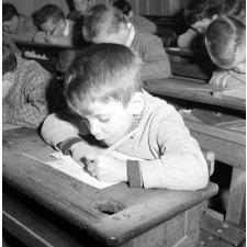 Ecole de garçons, rue Montcenis : exercice d'écriture dans la classe : un jeune garçon s'applique