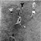 Pratique du sport sur un stade parisien : les élèves, sous la surveillance du professeur, effectuent exercices et jeux par groupes de deux.