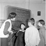 Classe de mal-entendants de Lestrade : les élèves et la maîtresse dans une salle décorée pour Noël, lors de la lecture expliquée. Lettre au Père Noël écrite au tableau.