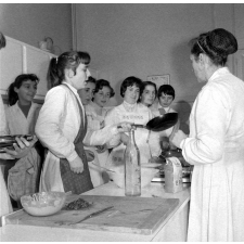 Collège d'enseignement technique pour jeunes filles. Le cours de cuisine. L'art du maniement de la poêle pour les crêpes.