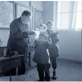 Ecole primaire. L'instituteur vérifie les travaux des élèves.
