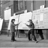Rentrée scolaire à Paris : des enfants dans la rue, jouant aux cowboys devant des affiches politiques