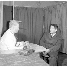 Visite médicale (cabinet mobile) à l'école primaire de Labruguière. Le médecin s'entretient avec l'instituteur au sujet du comportement et des résultats des élèves.