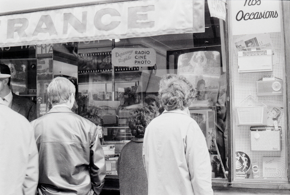 Personnages devant une boutique de télévisions